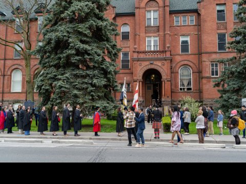 2024 Convocation graduates in robes outside front steps 2024 Convocation graduates in robes outside front steps