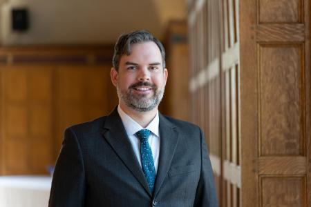 Jeffrey Hocking in Great  Hall against wood panelling (2025)