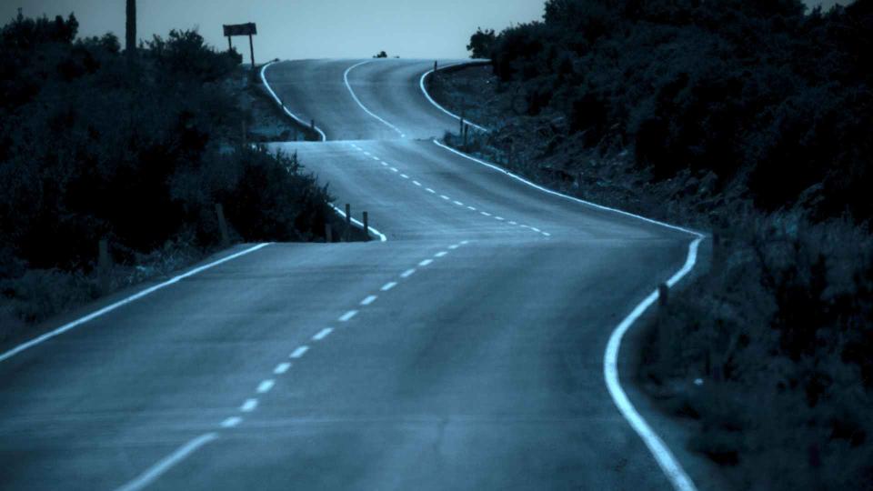 road on a wintry night winding through the hills 